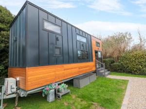 a black and orange tiny house in a yard at The Tiny Home in Yarm +6 photos