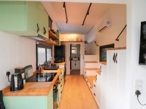 a kitchen with white cabinets and wooden counter tops at The Tiny Home in Yarm