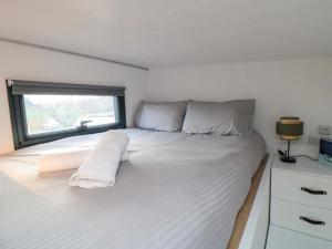 a white bed in a room with a window at The Tiny Home in Yarm