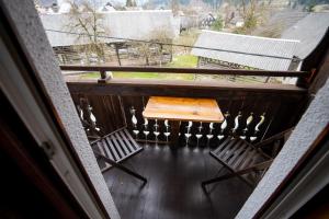 a balcony with a wooden table and two chairs at Apartments and rooms Pri Urhu in Bohinj