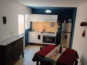 a small kitchen with a table and a refrigerator at Casa completa equipada para cualquier ocasión in Tezoyuca