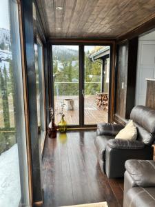 a living room with a couch and a large window at Kvitfjell in Ringebu +5 photos