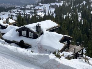 a house covered in snow on a mountain at Kvitfjell in Ringebu
