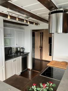 a kitchen with white cabinets and black counter tops at Kvitfjell in Ringebu