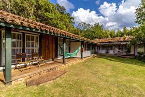 a house with a deck and a yard at Pousada Meu Recanto in Conceição da Ibitipoca
