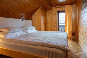 a bedroom with a bed in a room with a window at Apartments and rooms Pri Urhu in Bohinj