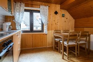 a kitchen with a table and chairs and a window at Apartments and rooms Pri Urhu in Bohinj