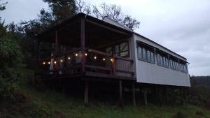 a house sitting on top of a hill with lights at Rivendell Forest Retreat in Wilderness +15 photos