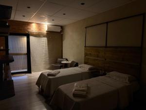 a hotel room with two beds and a chair at Casita de Ceci in Pilar