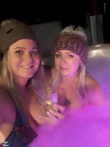 two women in a bath tub with a glass of wine at Wellness Chalupa Horní Orlice in Králíky