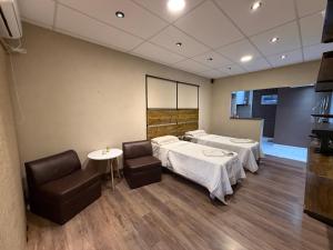 a hospital room with two beds and two chairs at Casita de Ceci in Pilar