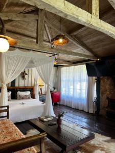 a bedroom with a large bed and a table at Pousada Meu Recanto in Conceição da Ibitipoca +179 photos