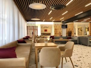 a lobby with couches and tables and chairs at Grand Hotel Sunny Beach - All Inclusive in Sunny Beach