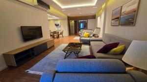 a living room with couches and a flat screen tv at Maison 7 Mirage Resort in Cairo