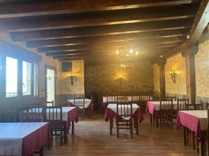 a dining room with tables and chairs and a chandelier at hotel rural ATALAYA in Alcañices