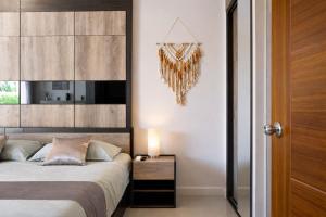 a bedroom with a bed and a table with a lamp at Condo Vireo Pool View Rawai in Phuket