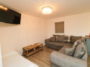 a living room with a couch and a tv at Toote Suite in Yarm