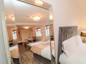 a bedroom with two beds and a mirror at Toote Suite in Yarm