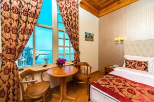 a hotel room with a bed and a table and a window at Mom Hotel Buyukada in Adalar