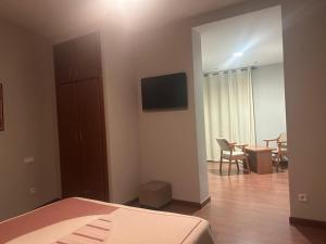 a bedroom with a bed and a television and a table at hotel rural ATALAYA in Alcañices