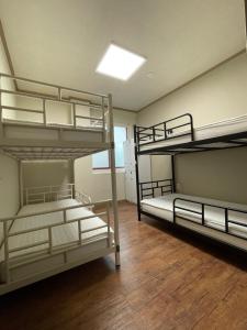 a room with three bunk beds in it at Baramgot Guesthouse in Gyeongju