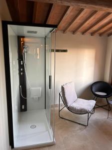 a glass shower with a chair next to a chair at CasaGozzante in Pienza +28 photos