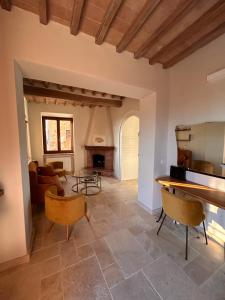 a living room with a fireplace and a table and chairs at CasaGozzante in Pienza