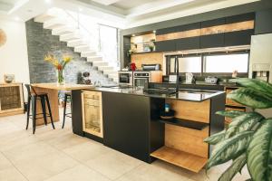 a kitchen with black cabinets and a kitchen island at Sublima Villa, Luxe et élégance in La Gaulette