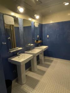 a bathroom with three sinks and three mirrors at Baramgot Guesthouse in Gyeongju