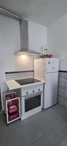a kitchen with a stove and a white refrigerator at Vivienda Turística de Alojamiento Rural - Labrucena in Abrucena