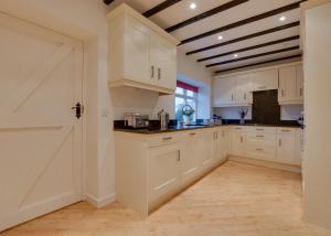 a kitchen with white cabinets and a wooden floor at 3 Bed in Caldbergh oc-ds911 in Caldbergh