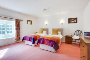 a bedroom with two beds and a desk and a window at 3 Bed in Caldbergh oc-ds911 in Caldbergh