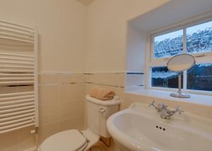 a bathroom with a toilet and a sink and a mirror at 3 Bed in Caldbergh oc-ds911 in Caldbergh