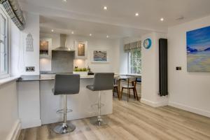 a kitchen with two bar stools and a dining room at 2 Bed in Kingsbridge oc-bc3188 in Kingsbridge +5 photos