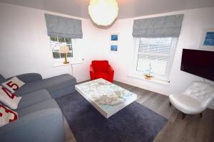 a living room with a couch and a red chair at 2 Bed in Kingsbridge oc-bc3188 in Kingsbridge