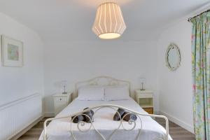 a white bedroom with a bed with goggles on it at 2 Bed in Kingsbridge oc-bc3188 in Kingsbridge