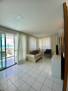 a living room with a couch and a view of the ocean at Hotel Ponta Negra Beach Natal in Natal