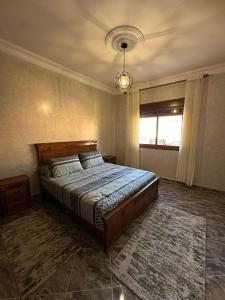 a bedroom with a large bed in a room at ZAHA Appart in Ksar es Sghir