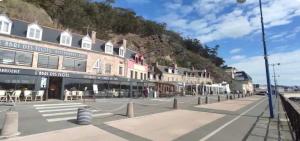 a street with a building on the side of a mountain at Superbe appartement face à la mer à Erquy in Erquy