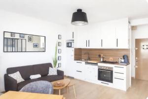 a living room with a couch and a kitchen at Superbe appartement face à la mer à Erquy in Erquy +11 photos