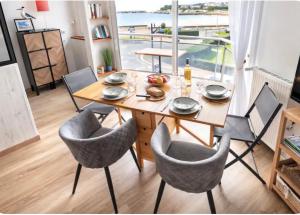 a dining room with a table and chairs and a large window at Superbe appartement face à la mer à Erquy in Erquy