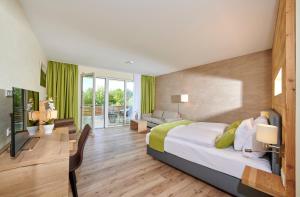 a bedroom with a large bed and a living room at Bachhof Resort Hotel in Straubing +49 photos