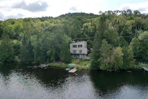 an aerial view of a house on an island in a lake at Lakeside Lodge at Tremblant in Brébeuf