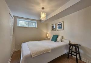a bedroom with a large white bed and a chandelier at Lakeside Lodge at Tremblant in Brébeuf