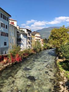 a river in a city with buildings and houses at Dream Home - Kapuziner Platz in Brunico