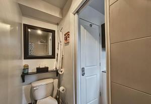 a small bathroom with a toilet and a mirror at Lakeside Lodge at Tremblant in Brébeuf