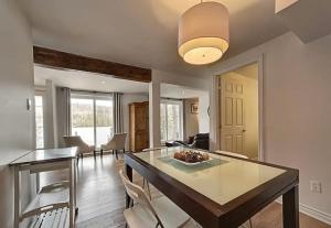 a living room with a dining room table and chairs at Lakeside Lodge at Tremblant in Brébeuf +7 photos