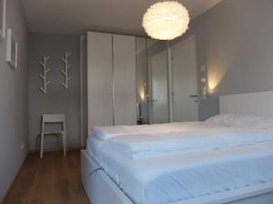 a bedroom with a large white bed and a chandelier at Dream Home - Kapuziner Platz in Brunico