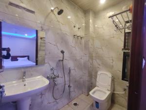 a white bathroom with a sink and a toilet at SB Royal Inn in Mysore +73 photos
