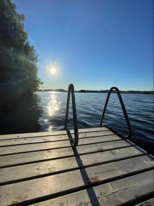 a dock on a lake with the sun in the background at Itärajan Helmi in Tohmajärvi +138 photos